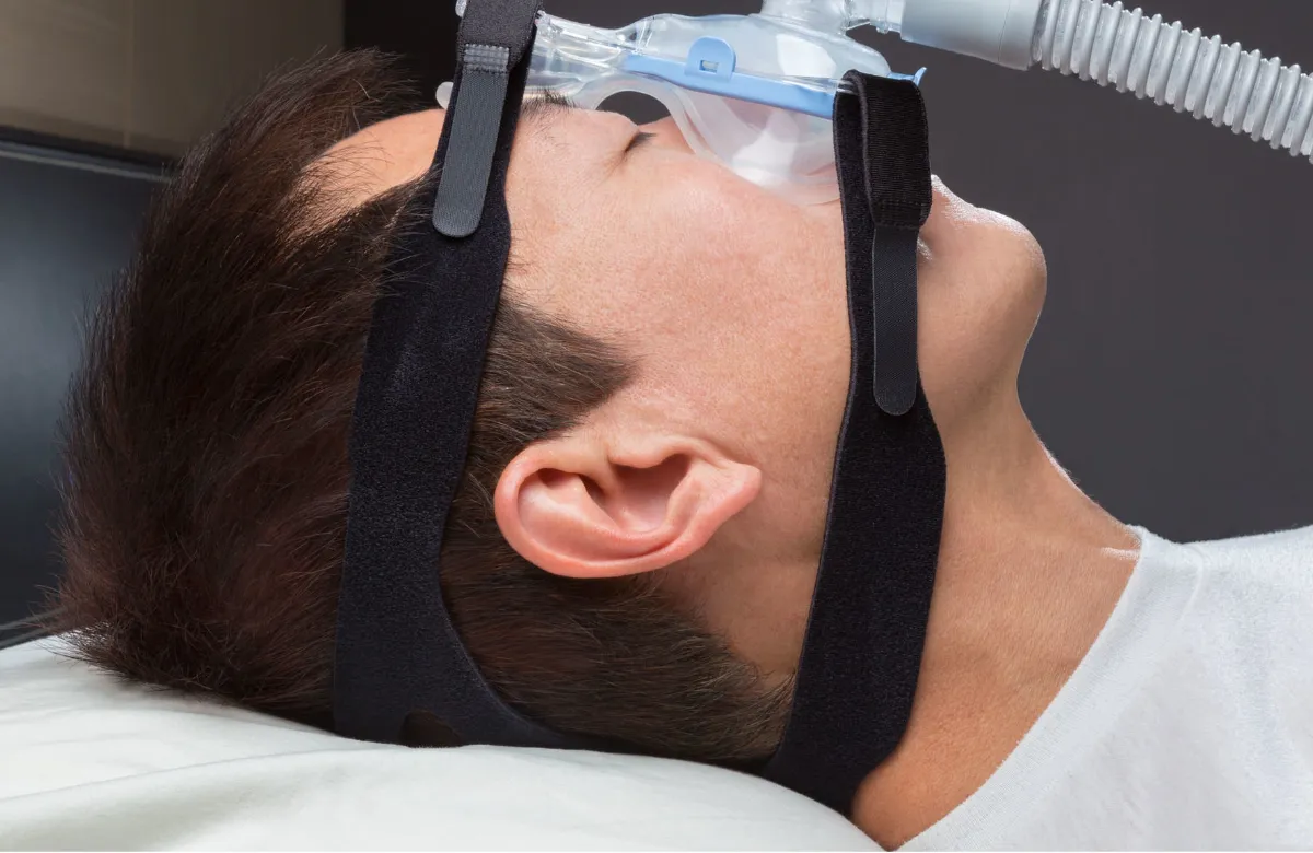 Person wearing RespiraPro headgear, with a separate CPAP mask shown alongside